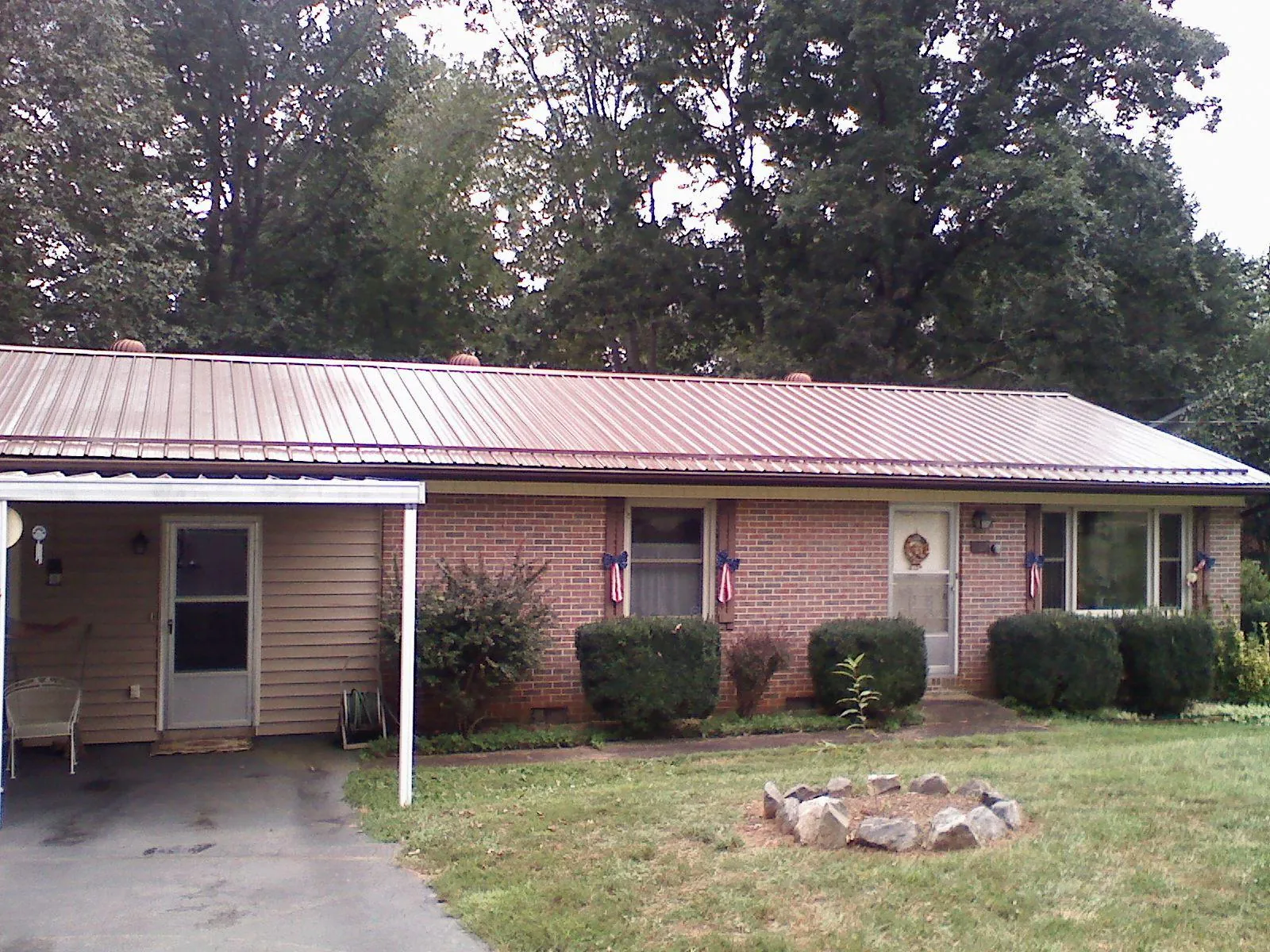 Bronze metal roof and carport on a brick ranch home — Roof Repair work by our crew in Black River